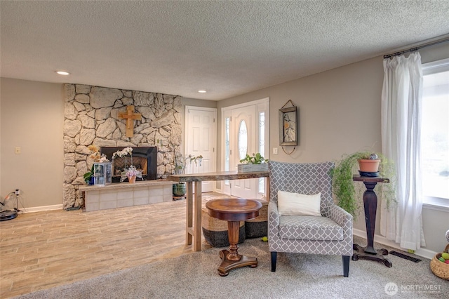 717 Judith Ct, Aberdeen, WA 98520 - living area with a textured ceiling, a stone fireplace, and wood finished floors
