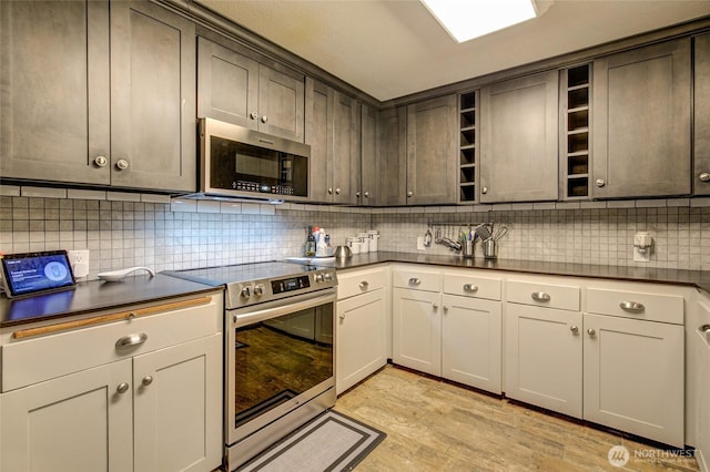 717 Judith Ct, Aberdeen, WA 98520 - kitchen with appliances with stainless steel finishes, dark countertops, open shelves, backsplash, and light wood finished floors