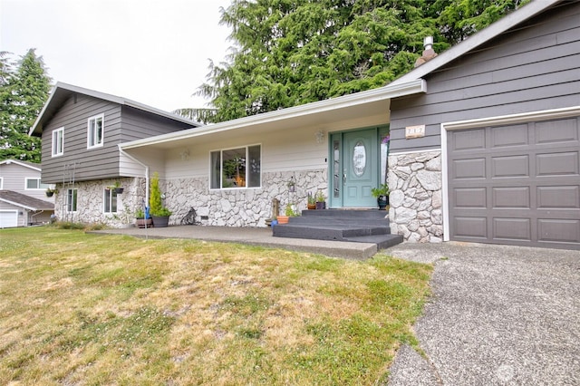 717 Judith Ct, Aberdeen, WA 98520 - split level home with stone siding, a front yard, and a garage