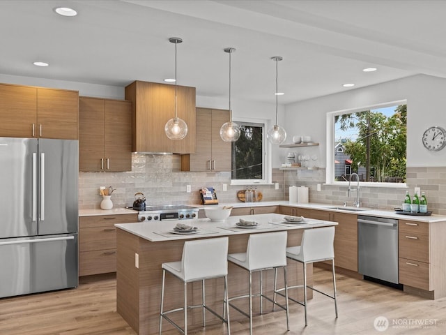 9015 Dibble Ave NW, Seattle, WA 98117 - kitchen with appliances with stainless steel finishes, brown cabinets, a breakfast bar area, decorative backsplash, and recessed lighting