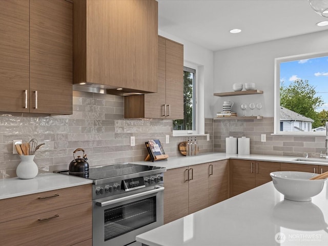 9015 Dibble Ave NW, Seattle, WA 98117 - kitchen with stainless steel electric range, light countertops, backsplash, and brown cabinetry