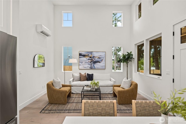 333 18th Ave, Kirkland, WA 98033 - living area featuring a wall unit AC, a high ceiling, and wood finished floors