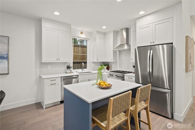 333 18th Ave, Kirkland, WA 98033 - kitchen featuring appliances with stainless steel finishes, wall chimney range hood, a kitchen bar, white cabinets, and recessed lighting