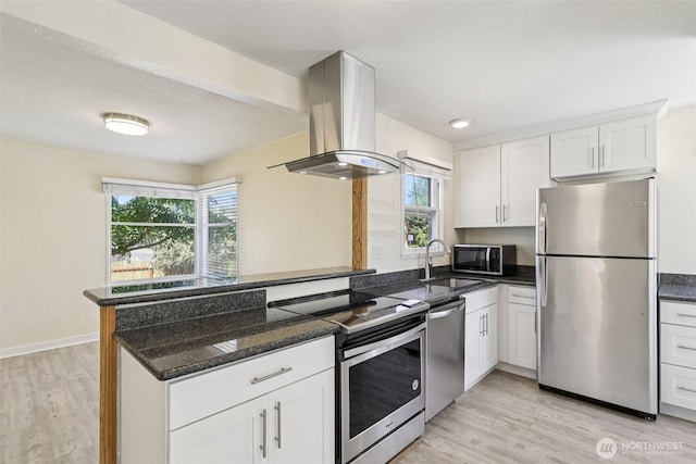 11303 Park Ave S, Tacoma, WA 98444 - kitchen with stainless steel appliances, island range hood, a peninsula, white cabinets, and plenty of natural light