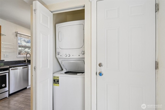 11303 Park Ave S, Tacoma, WA 98444 - laundry area featuring stacked washer and clothes dryer and wood finished floors