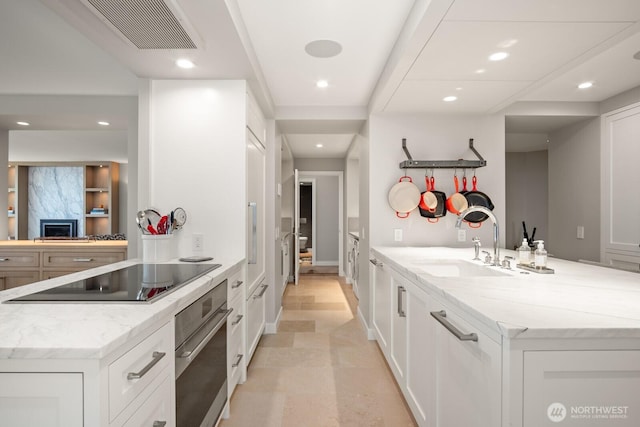 1620 43rd Ave E Unit 15A-B, Seattle, WA 98112 - kitchen featuring stainless steel oven, a peninsula, recessed lighting, white cabinetry, and black electric stovetop