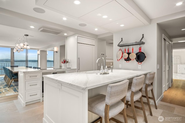 1620 43rd Ave E Unit 15A-B, Seattle, WA 98112 - kitchen with a peninsula, white cabinets, light stone countertops, a breakfast bar area, and recessed lighting