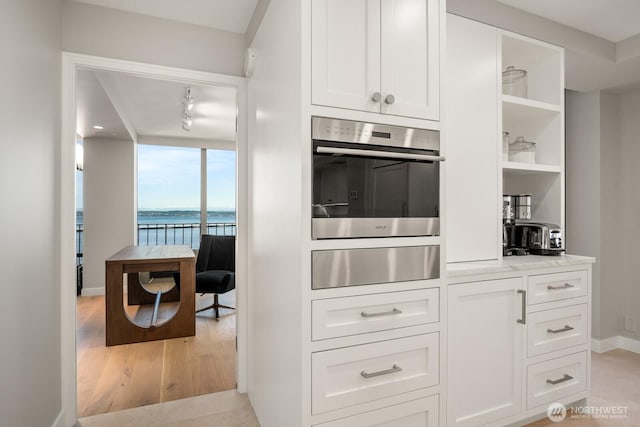 1620 43rd Ave E Unit 15A-B, Seattle, WA 98112 - kitchen featuring open shelves, oven, white cabinets, a water view, and light wood-style flooring