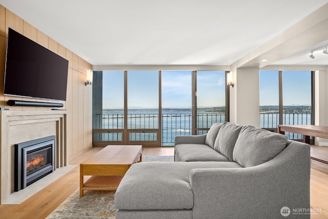 1620 43rd Ave E Unit 15A-B, Seattle, WA 98112 - living room with light wood-type flooring, a water view, a fireplace with flush hearth, and floor to ceiling windows