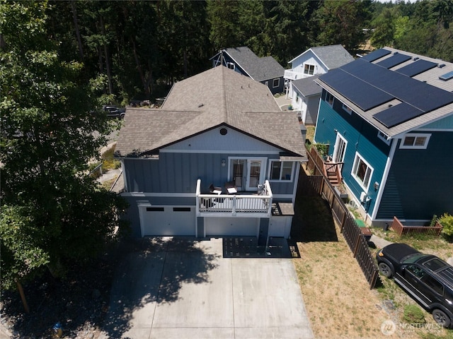 408 Eddy Ct, Port Townsend, WA 98368 - view of front facade featuring driveway, board and batten siding, roof with shingles, and an attached garage