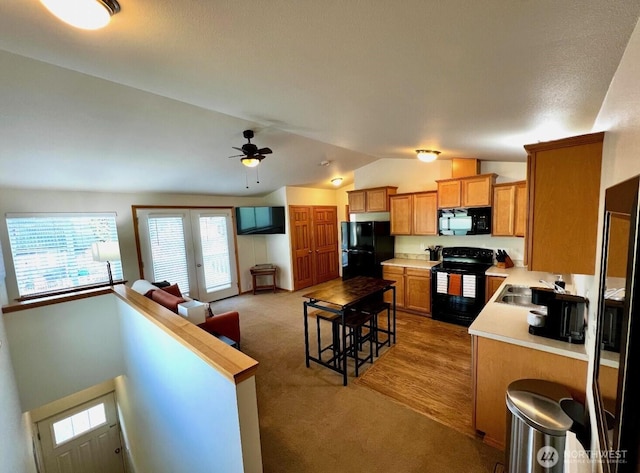 408 Eddy Ct, Port Townsend, WA 98368 - kitchen featuring black appliances, vaulted ceiling, light colored carpet, light countertops, and open floor plan