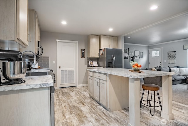 3563 Sweet Rd, Blaine, WA 98230 - kitchen featuring fridge with ice dispenser, light countertops, a kitchen bar, a center island, and crown molding