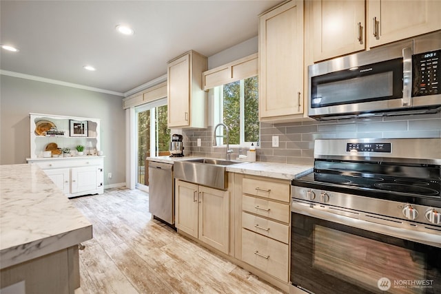 3563 Sweet Rd, Blaine, WA 98230 - kitchen featuring appliances with stainless steel finishes, crown molding, light wood-style flooring, tasteful backsplash, and light brown cabinetry
