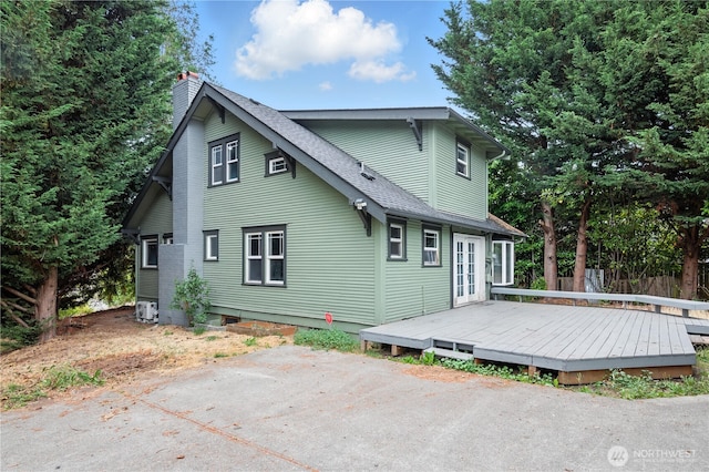 4061 E Howe St, Tacoma, WA 98404 - back of property featuring a deck, roof with shingles, a chimney, and french doors