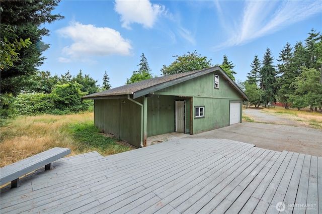 4061 E Howe St, Tacoma, WA 98404 - wooden terrace featuring a garage, an outdoor structure, and driveway