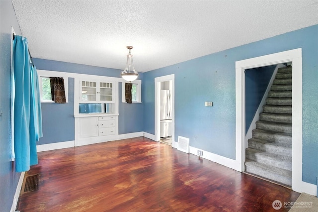 4061 E Howe St, Tacoma, WA 98404 - spare room featuring wood finished floors, a textured ceiling, and stairway