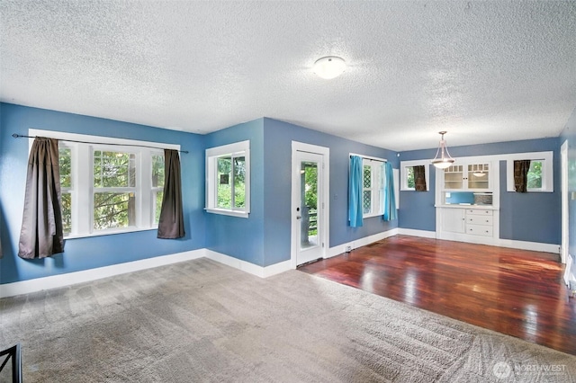 4061 E Howe St, Tacoma, WA 98404 - unfurnished room with healthy amount of natural light, a textured ceiling, carpet flooring, and wood finished floors