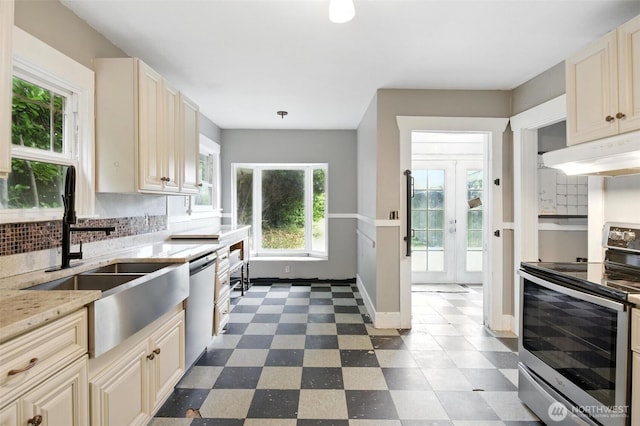 4061 E Howe St, Tacoma, WA 98404 - kitchen with stainless steel appliances, under cabinet range hood, cream cabinets, and dark floors
