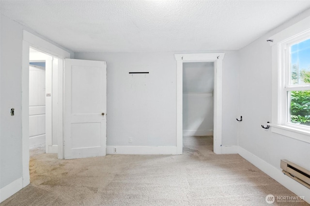 4061 E Howe St, Tacoma, WA 98404 - unfurnished bedroom featuring baseboard heating, carpet, a textured ceiling, and a spacious closet