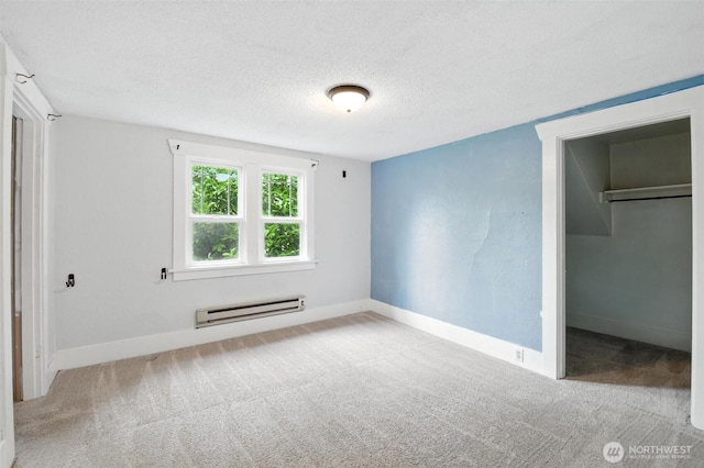 4061 E Howe St, Tacoma, WA 98404 - unfurnished bedroom featuring baseboard heating, carpet floors, a walk in closet, and a textured ceiling