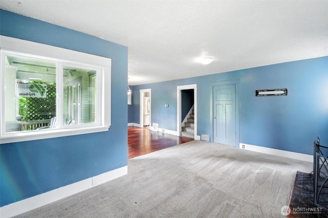 4061 E Howe St, Tacoma, WA 98404 - empty room featuring stairway, carpet, and a textured ceiling