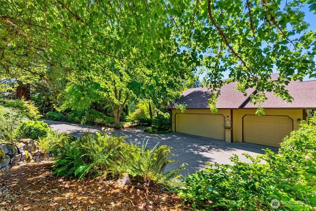 6701 Macintosh Ct SE, Olympia, WA 98513 - view of front of house featuring an attached garage, asphalt driveway, and roof with shingles