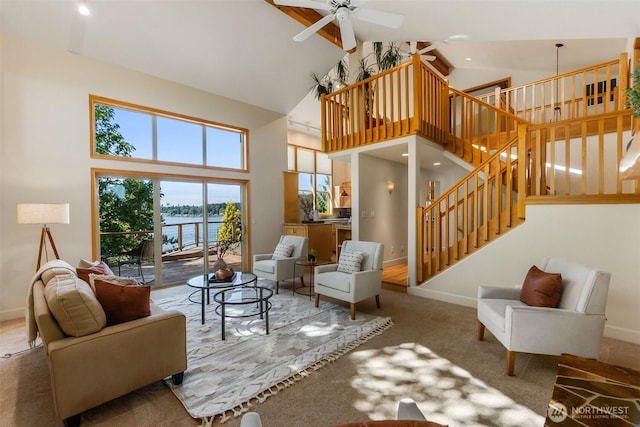 6701 Macintosh Ct SE, Olympia, WA 98513 - carpeted living area with high vaulted ceiling, ceiling fan, stairs, a water view, and beamed ceiling