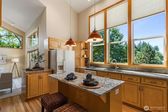 6701 Macintosh Ct SE, Olympia, WA 98513 - kitchen featuring white appliances, high vaulted ceiling, light wood-type flooring, dark stone counters, and decorative light fixtures