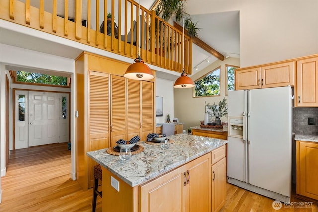 6701 Macintosh Ct SE, Olympia, WA 98513 - kitchen with white refrigerator with ice dispenser, light wood-type flooring, decorative backsplash, a kitchen island, and light brown cabinetry