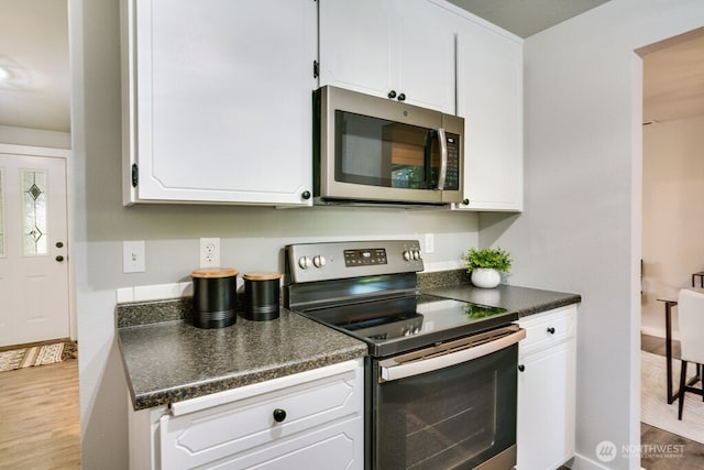 8106 186th Street Ct E, Puyallup, WA 98375 - kitchen with appliances with stainless steel finishes, dark countertops, white cabinets, and wood finished floors
