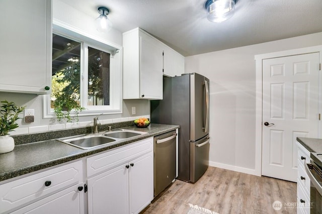 8106 186th Street Ct E, Puyallup, WA 98375 - kitchen featuring dark countertops, white cabinets, light wood-style flooring, and stainless steel appliances