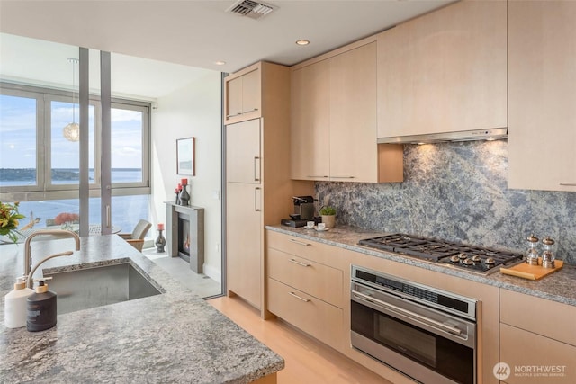 1521 2nd Ave Unit 2303, Seattle, WA 98101 - kitchen featuring appliances with stainless steel finishes, tasteful backsplash, recessed lighting, a water view, and light stone counters