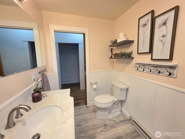 321 12th St, Raymond, WA 98577 - bathroom with a wainscoted wall, wood finished floors, a baseboard radiator, and vanity