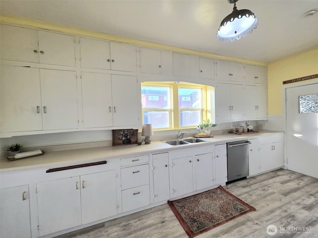 321 12th St, Raymond, WA 98577 - kitchen featuring dishwasher, light wood-type flooring, light countertops, and white cabinetry