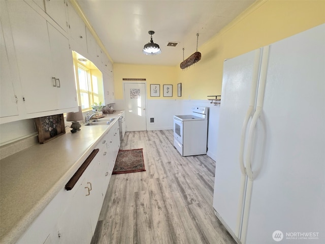321 12th St, Raymond, WA 98577 - kitchen featuring white appliances, light wood-style floors, washer / clothes dryer, white cabinets, and light countertops