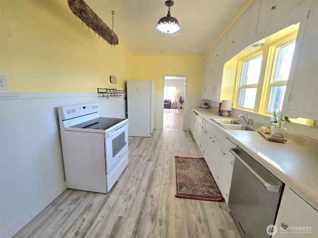 321 12th St, Raymond, WA 98577 - kitchen featuring white appliances, light wood-style flooring, white cabinets, light countertops, and decorative light fixtures
