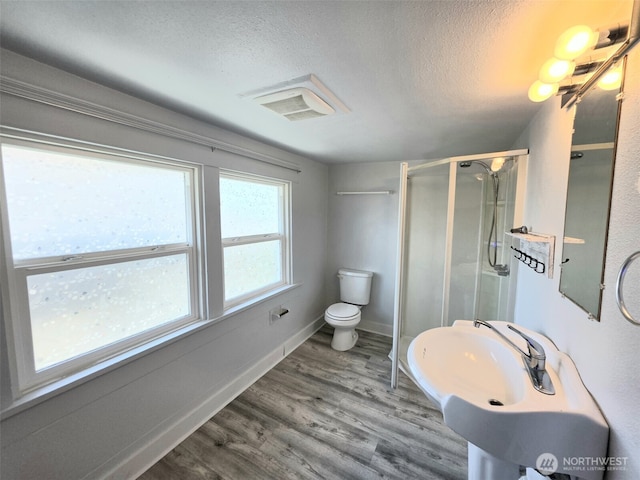 321 12th St, Raymond, WA 98577 - bathroom with a textured ceiling, a shower stall, and wood finished floors