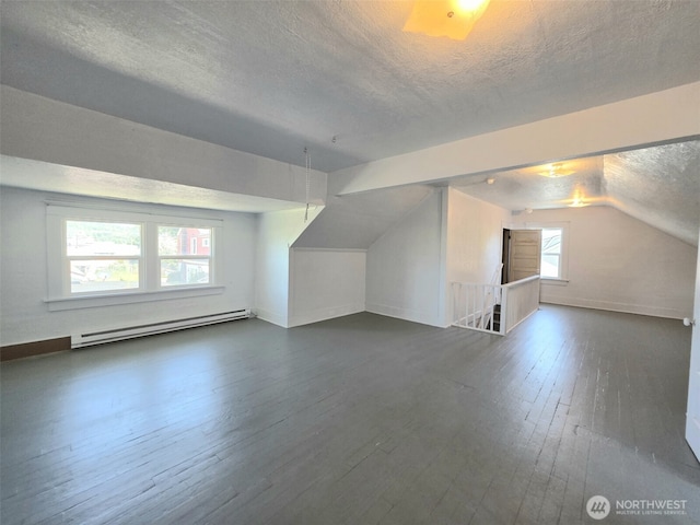 321 12th St, Raymond, WA 98577 - additional living space featuring baseboard heating, a textured ceiling, dark wood finished floors, and vaulted ceiling