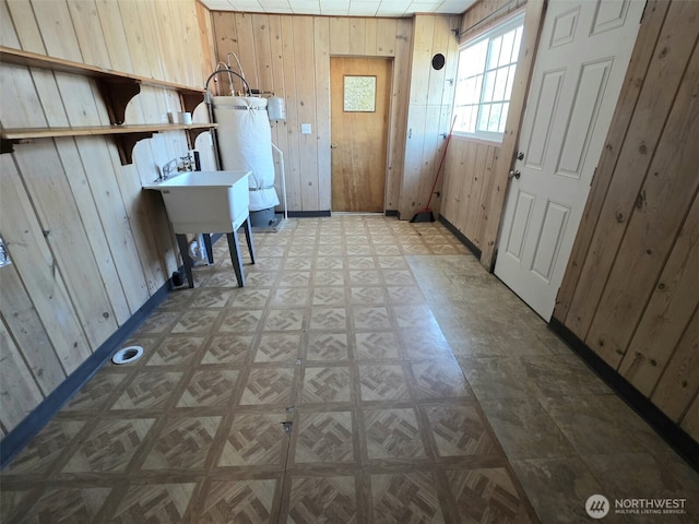 321 12th St, Raymond, WA 98577 - laundry room with water heater, wood walls, and light flooring