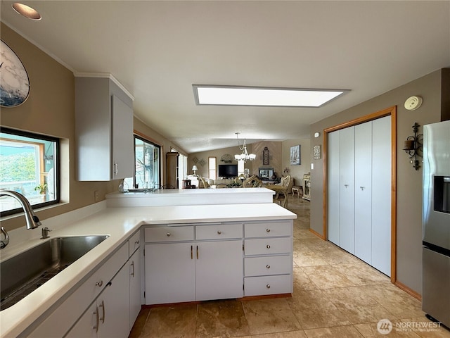 101 Sand Dune Ave NW, Ocean Shores, WA 98569 - kitchen with stainless steel fridge, light countertops, open floor plan, a peninsula, and a chandelier