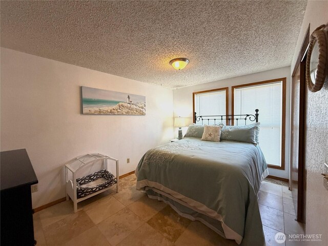 101 Sand Dune Ave NW, Ocean Shores, WA 98569 - tiled bedroom featuring a textured ceiling and baseboards
