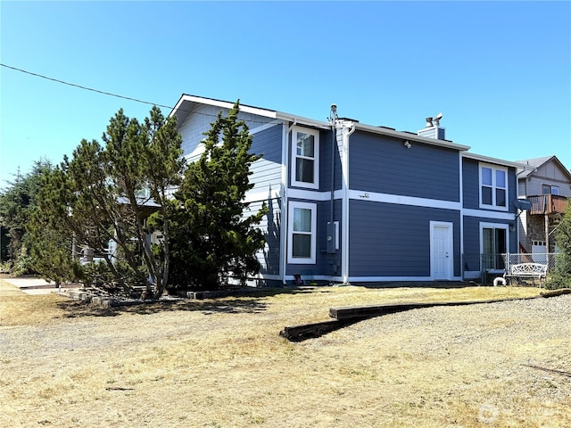 101 Sand Dune Ave NW, Ocean Shores, WA 98569 - rear view of property featuring a chimney