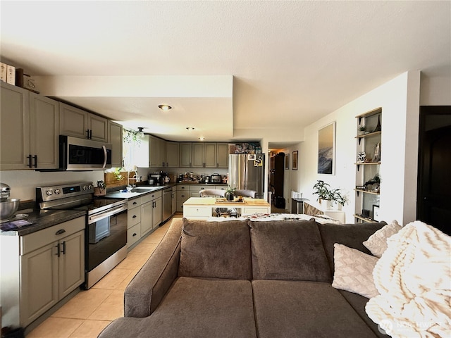 101 Sand Dune Ave NW, Ocean Shores, WA 98569 - kitchen with stainless steel appliances, open floor plan, dark countertops, gray cabinetry, and light tile patterned floors