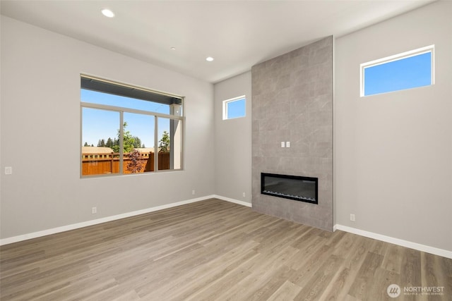 13931 178th St E Unit 39, Puyallup, WA 98374 - unfurnished living room with wood finished floors, a tiled fireplace, and recessed lighting