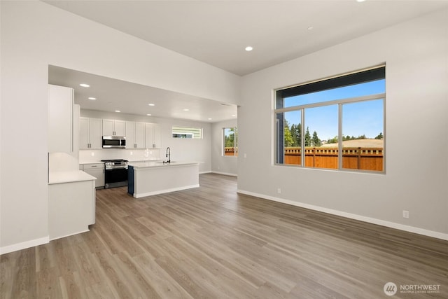 13931 178th St E Unit 39, Puyallup, WA 98374 - unfurnished living room with light wood-style flooring and recessed lighting