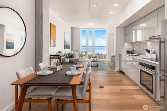 450 S Main St Unit 1608, Seattle, WA 98104 - dining space featuring light wood finished floors, a water view, and expansive windows