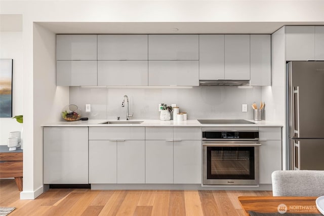 450 S Main St Unit 1608, Seattle, WA 98104 - kitchen with appliances with stainless steel finishes, exhaust hood, light countertops, and modern cabinets