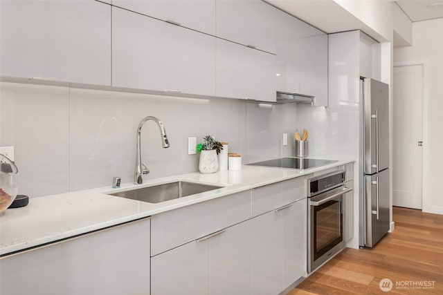 450 S Main St Unit 1608, Seattle, WA 98104 - kitchen featuring appliances with stainless steel finishes, modern cabinets, under cabinet range hood, and white cabinets