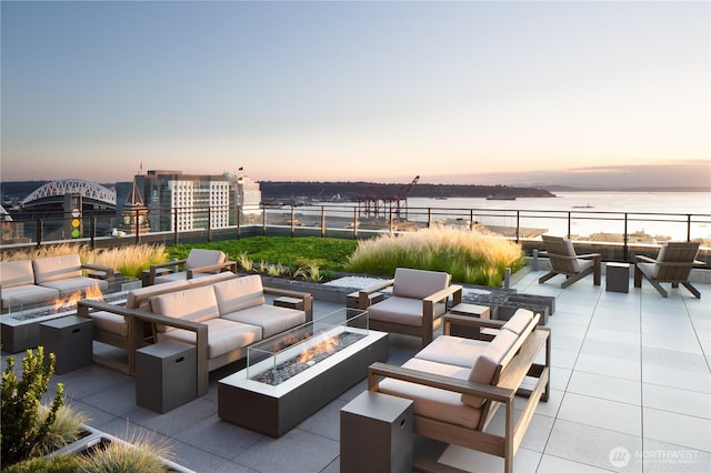 450 S Main St Unit 1608, Seattle, WA 98104 - patio terrace at dusk featuring an outdoor living space with a fire pit, a patio, and a water view