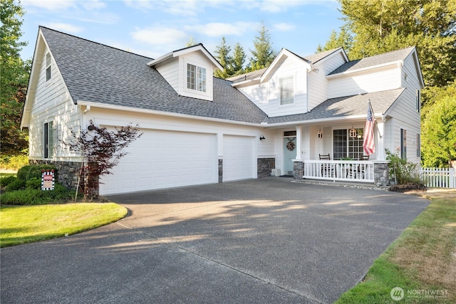 2060 Hammond Ave, Dupont, WA 98327 - view of front facade with driveway, covered porch, an attached garage, stone siding, and a shingled roof